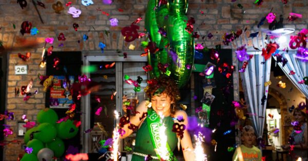 Festive birthday celebration with balloons, cake, and colorful confetti, highlighting a joyful atmosphere indoors.