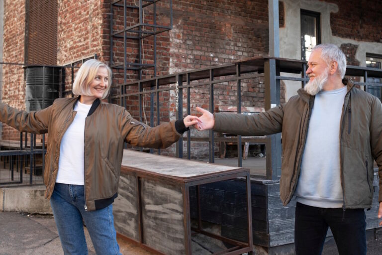 Getrennt leben akzeptieren: erwachsenes Paar hält mit Abstand die Hände, verbunden und lächelnd im urbanen Umfeld.