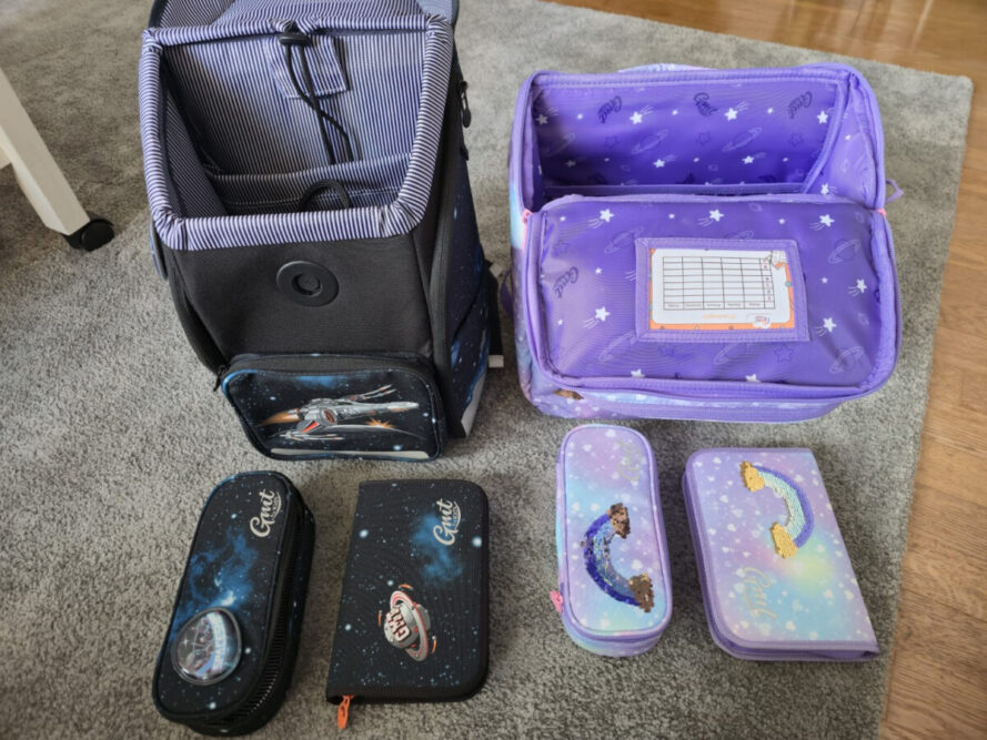 GMT WALL und GMT LIGHT Schulranzen-Sets komplett ausgebreitet – Mäppchen, Turnbeutel, Regenhülle und Kletties im direkten Vergleich