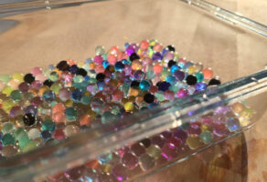 Wasserkügelchen entsorgen: bunte Hydroperlen in einer Glasschale auf dem Tisch