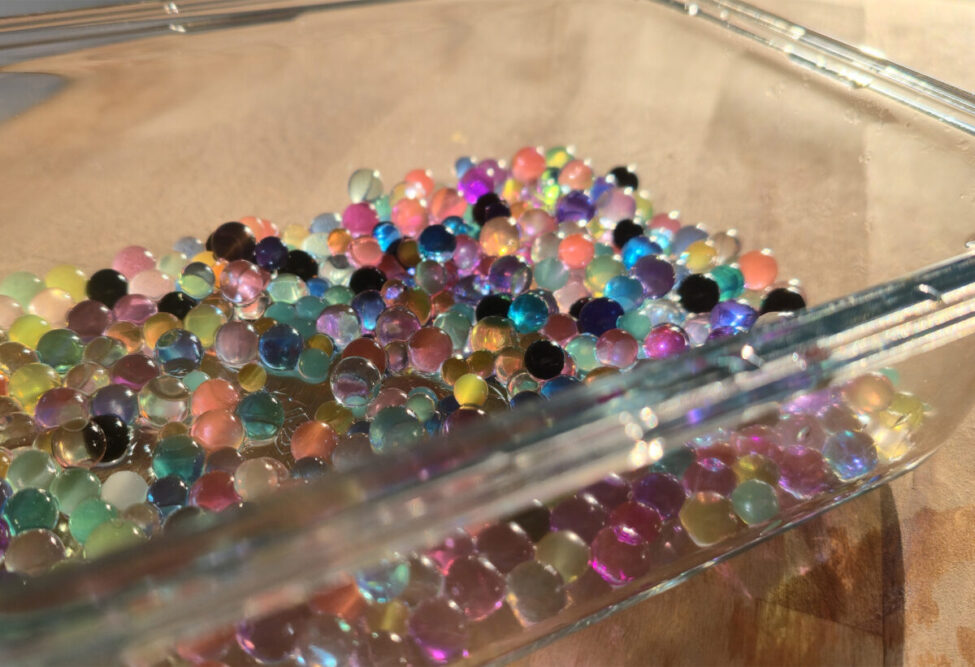 Wasserkügelchen entsorgen: bunte Hydroperlen in einer Glasschale auf dem Tisch