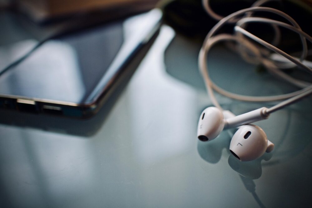 Kabelgebundene In-Ear-Kopfhörer liegen neben einem Smartphone