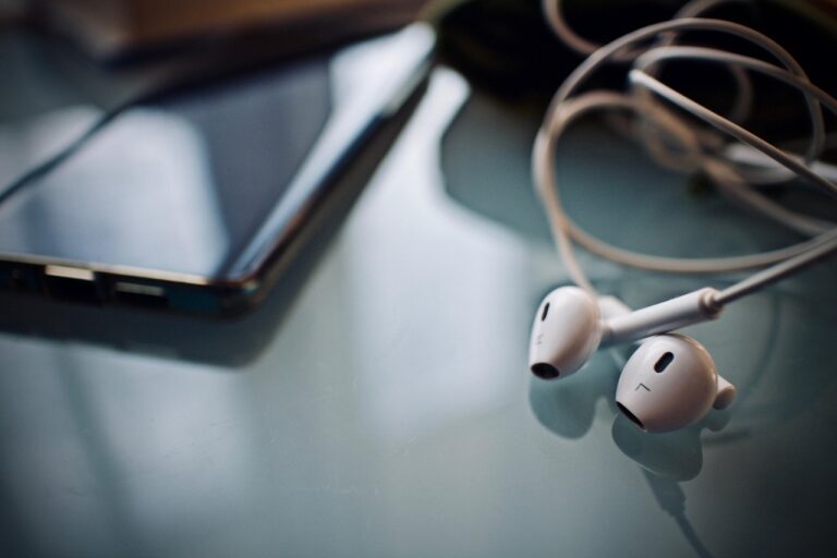 Kabelgebundene In-Ear-Kopfhörer liegen neben einem Smartphone