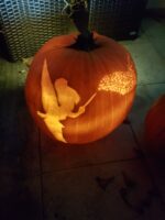 Geschnitzter Kürbis mit Tinkerbell-Silhouette und vielen kleinen Lichtpunkten als Feenstaub