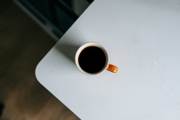 eine Tasse kalter Kaffee auf dem Küchentisch von oben