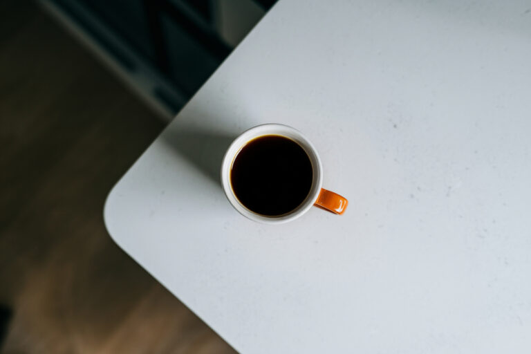 eine Tasse kalter Kaffee auf dem Küchentisch von oben