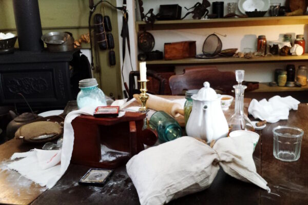 Unordentlicher Küchentisch mit Geschirr, Gläsern und verstreuten Utensilien - eine Szene, die erste Messie-Tendenzen erkennen lässt.