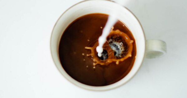 Tasse Kaffee mit sichtbar ausgeflockter Milch auf der Oberfläche