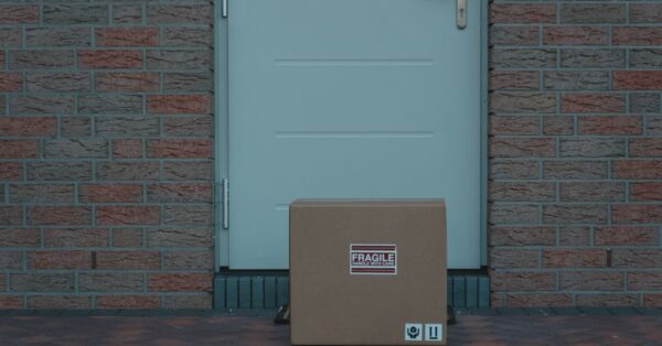 Paket vor einer Haustür zwischen Backsteinwänden