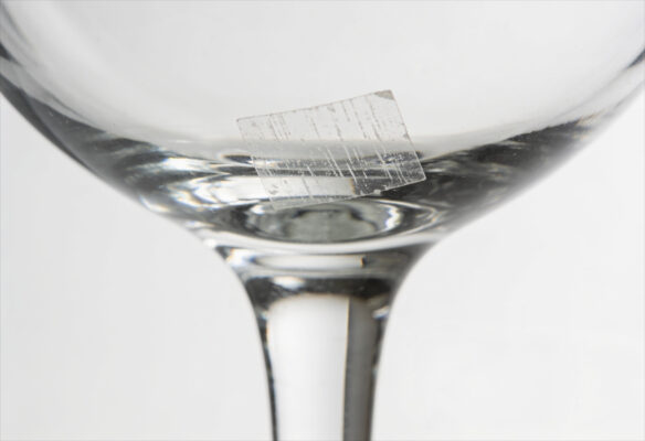 Reste eines klebendem Preisschild auf einem Glas
