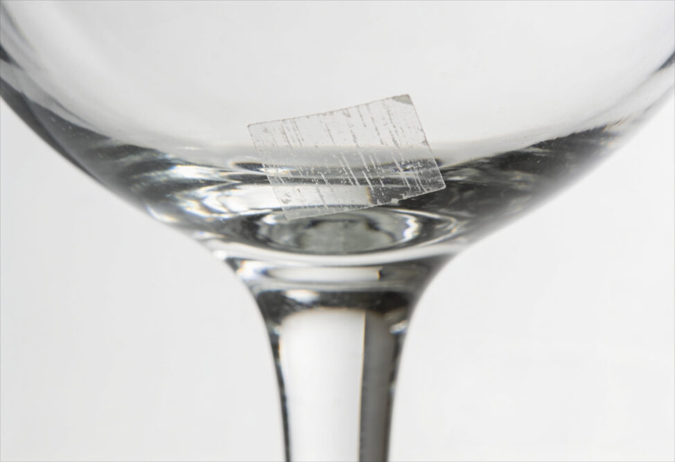 Reste eines klebendem Preisschild auf einem Glas