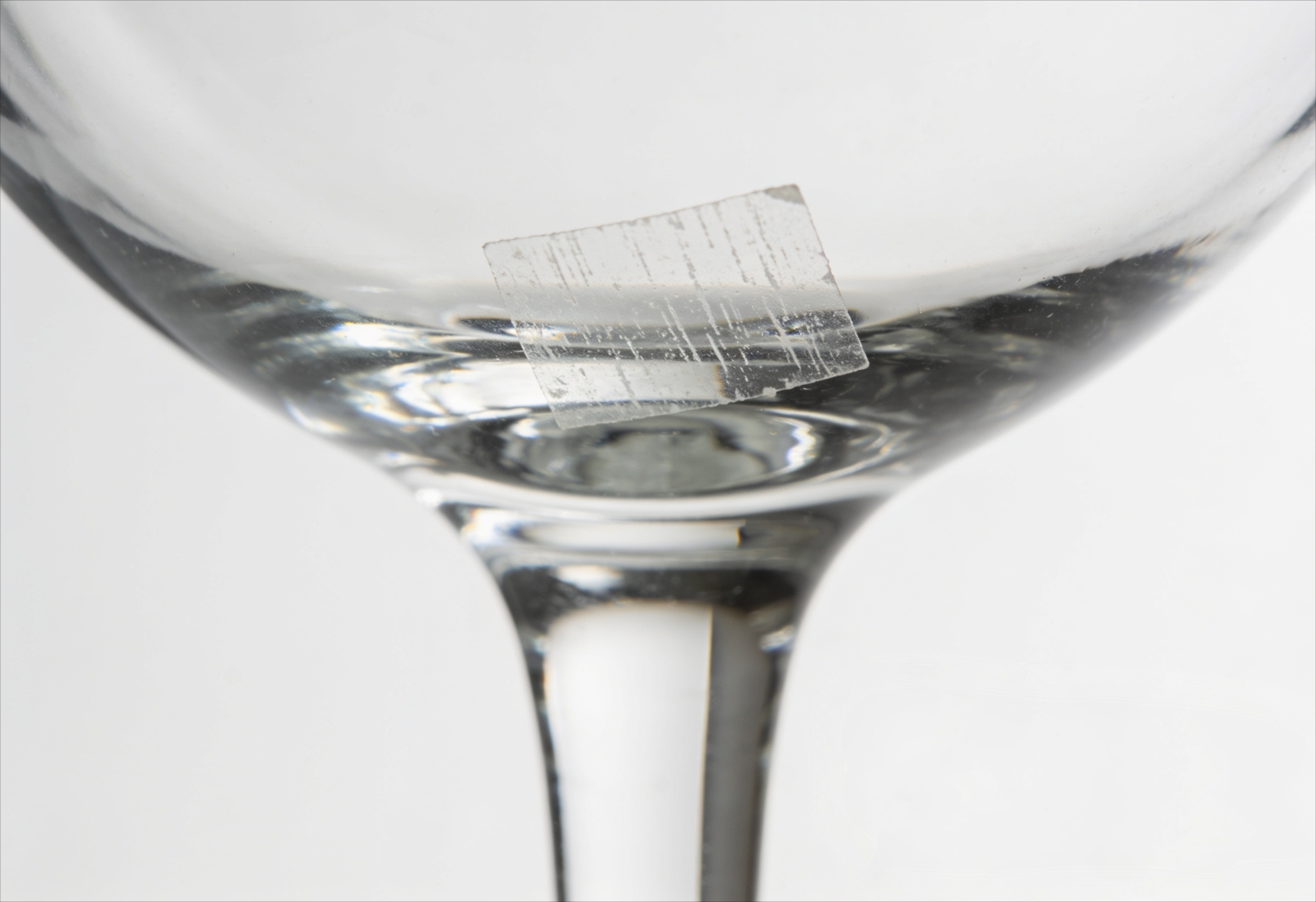 Reste eines klebendem Preisschild auf einem Glas