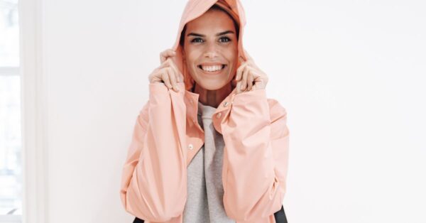 Frau trägt eine helle Regenjacke mit Kapuze