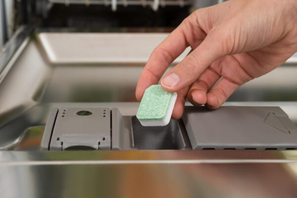 Spülmaschinentab wird in das Reinigerfach einer geöffneten Spülmaschine gelegt