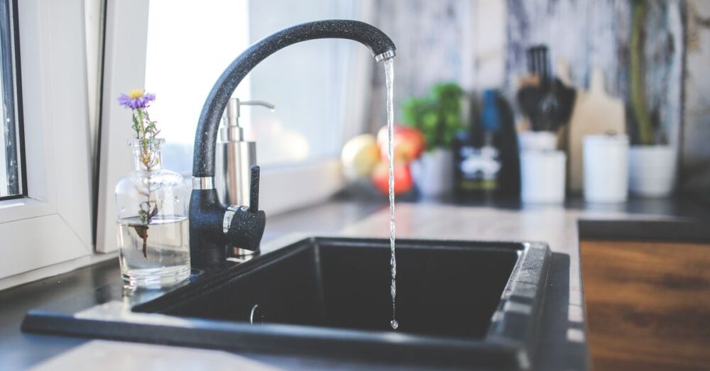 Laufender Wasserhahn mit wenig Druck über einer Küchenspüle