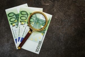 100 € Scheine unter einer Lupe als Symbolbild für den Ratgeber: Wie erkenne ich Falschgeld?